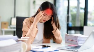 A office lady is having tension headache while working